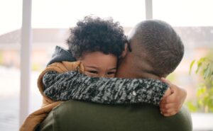 httpscdn.britannica.com59223259-050-5FC11D2ELittle-boy-hugging-father-parent-child.jpg