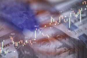Closeup Benjamin Franklin face on USD banknote with stock market chart graph and American flag for currency exchange and global trade forex concept.